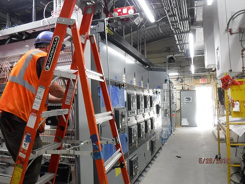 Tecnico che riconfigura i cavi in un armadio SCADA di una sottostazione elettrica