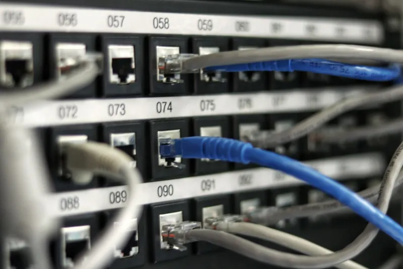 Patch panel di rete con cavi Ethernet collegati a porte RJ45 numerate